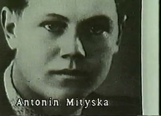 A period portrait of a young fair haired man in a dark jacket, the name Antonin Mityska captioned across the foot of the picture