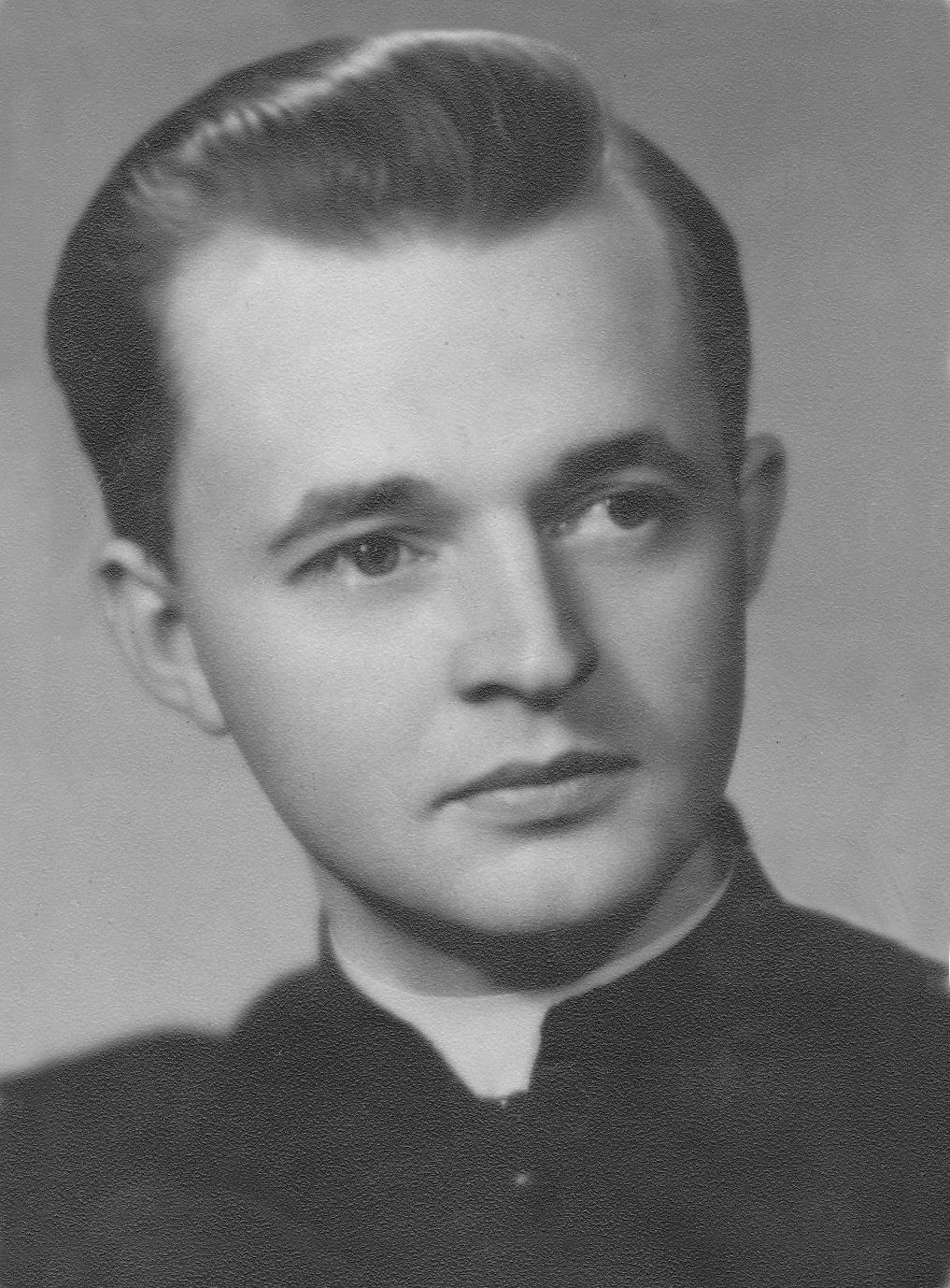Jan Bula, head and shoulders portrait of a young priest in a Roman collar