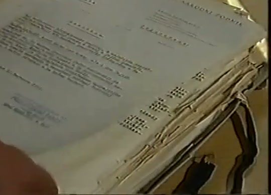 A thick stack of typed resolutions held open on a desk, the top sheet headed by the name of a national committee and stamped and signed at the foot