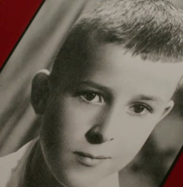 A black and white studio portrait of a small boy, from a family album