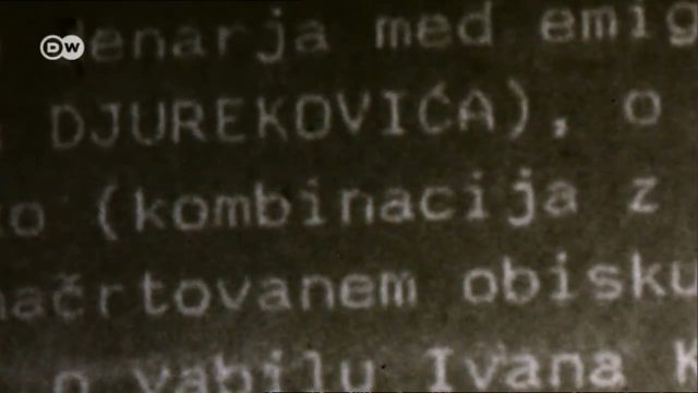 A typewritten file page photographed in extreme close up, the surname DJUREKOVICA in capitals on the second line, with Slovene wording around it about money among emigres, a planned visit and an invitation