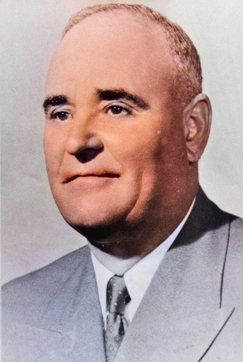 A sepia head and shoulders portrait of Gheorghe Gheorghiu-Dej in a suit and tie, looking past the camera