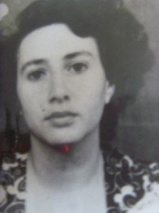 An identity photograph of Monica Sevianu, dark wavy hair, a patterned collar over a plain dress