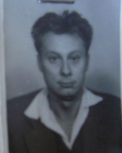 An identity photograph of Sașa Mușat, light hair swept back, a white shirt under a dark jacket