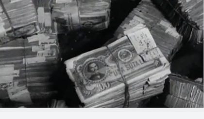 Banded bundles of banknotes seen from above, the top note reading UNA SUTĂ LEI, one hundred lei, with paper tags tucked under the bands
