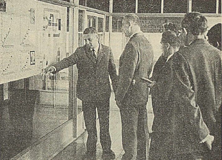 Men in suits at a wall of charts and diagrams inside the ZETO computing centre in Katowice, in a press photograph