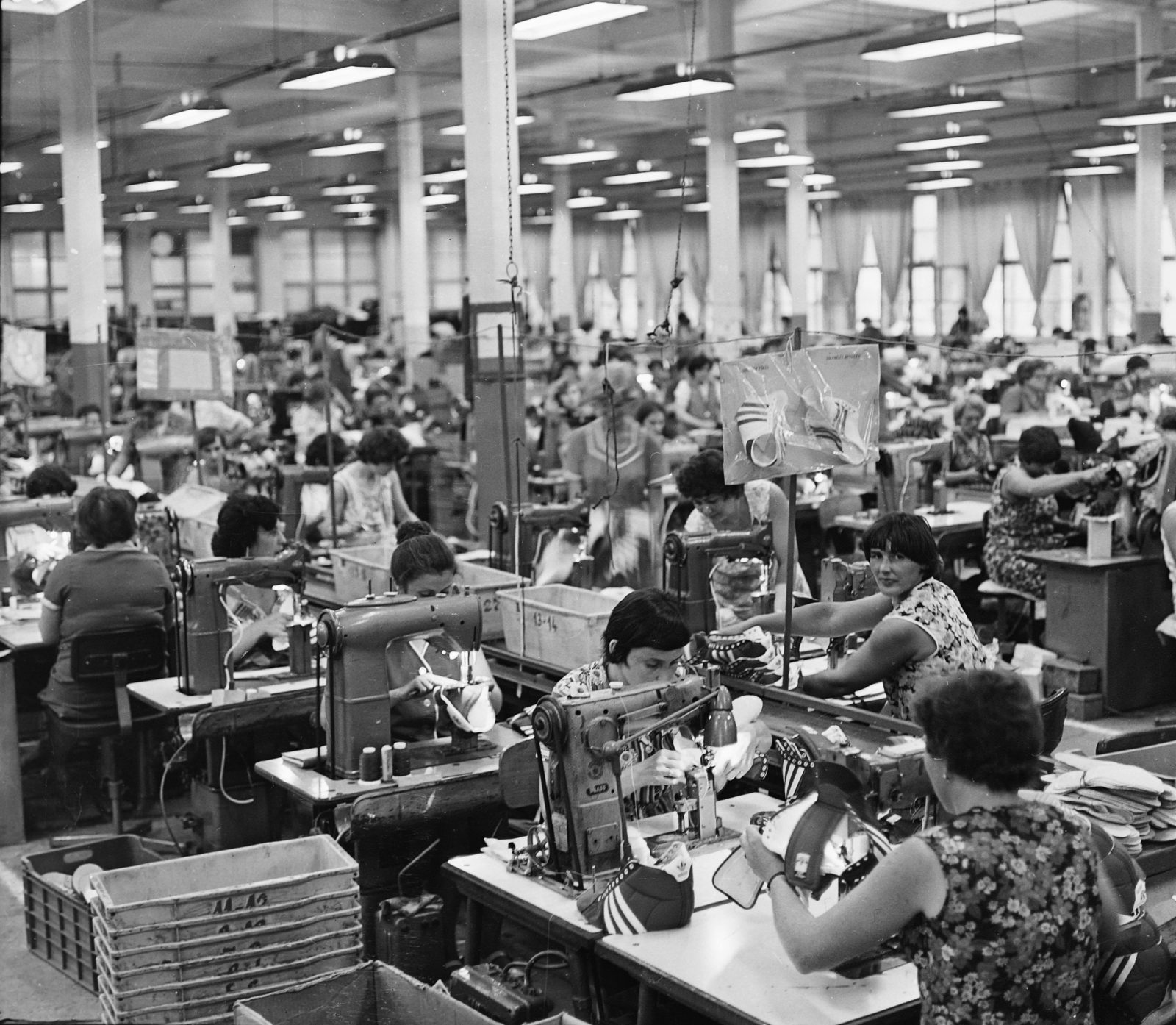 Women working at rows of sewing machines inside the Tisza shoe factory at Martfu, 1980