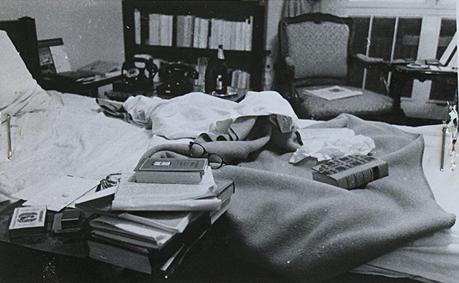 The unmade bed in Jan Masaryk's bedroom on 10 March 1948, papers and telegrams spread over the covers with two books and a pair of spectacles among them, and a bedside table carrying a telephone, a bottle and a carafe
