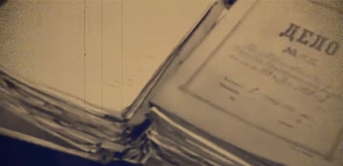 A close up of a thick bound case volume, its cover headed DELO, the Russian word for case, with the number and the entries filled in by hand