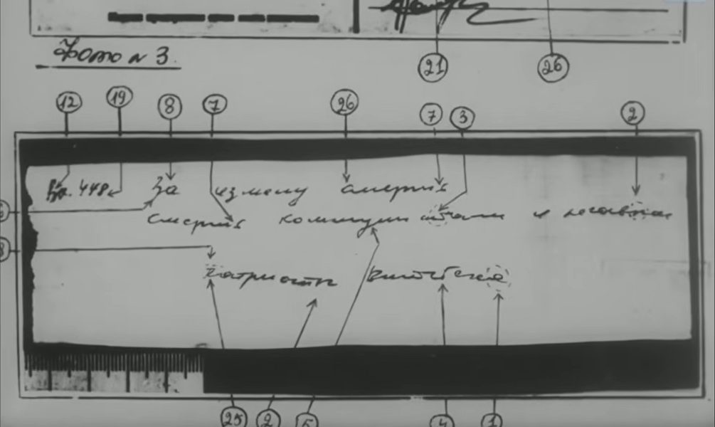 A page of a handwriting expert's report headed Photograph No. 3, showing the note enlarged and photographed against a ruler, with twenty numbered arrows drawn to the letters being compared