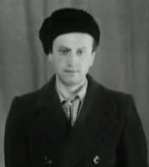 Vladimir Ionesyan, head and shoulders, in a fur hat with the ear flaps down and a dark double breasted coat over a checked shirt