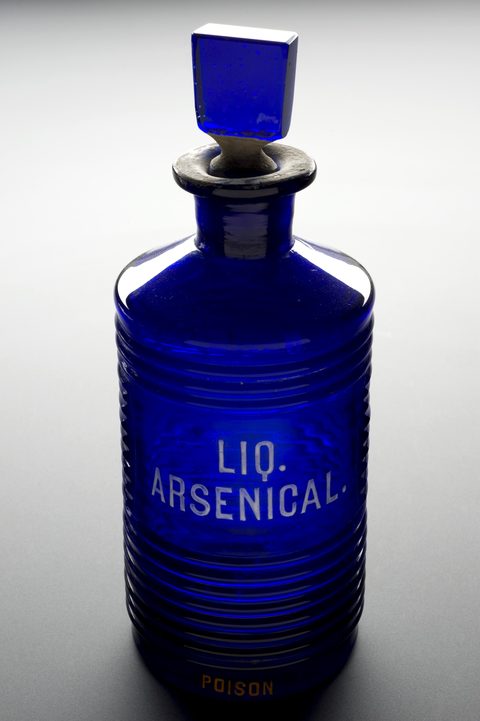 A blue ridged glass bottle used for arsenic in Europe between 1701 and 1935, photographed against a plain ground