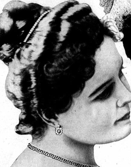 A halftone newspaper photograph of a young woman in a bare shouldered gown, a string of pearls at her throat, her hair swept up under a wide beaded band, her face turned down and away from the camera