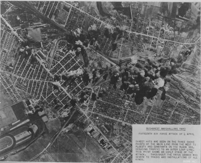 A United States reconnaissance print looking straight down on Bucharest, bomb bursts across the railway yards, with a typed caption block reading Bucharest Marshalling Yard, Fifteenth Air Force attack of 4 April