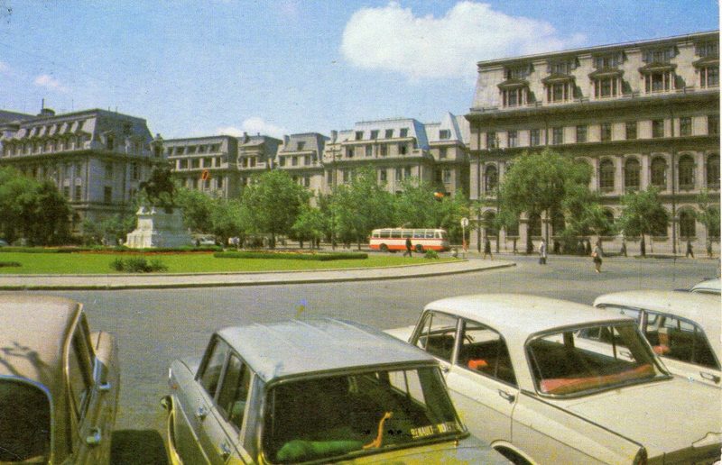 University Square in Bucharest in 1967, a trolleybus crossing in front of the buildings on the far side and parked cars along the near kerb
