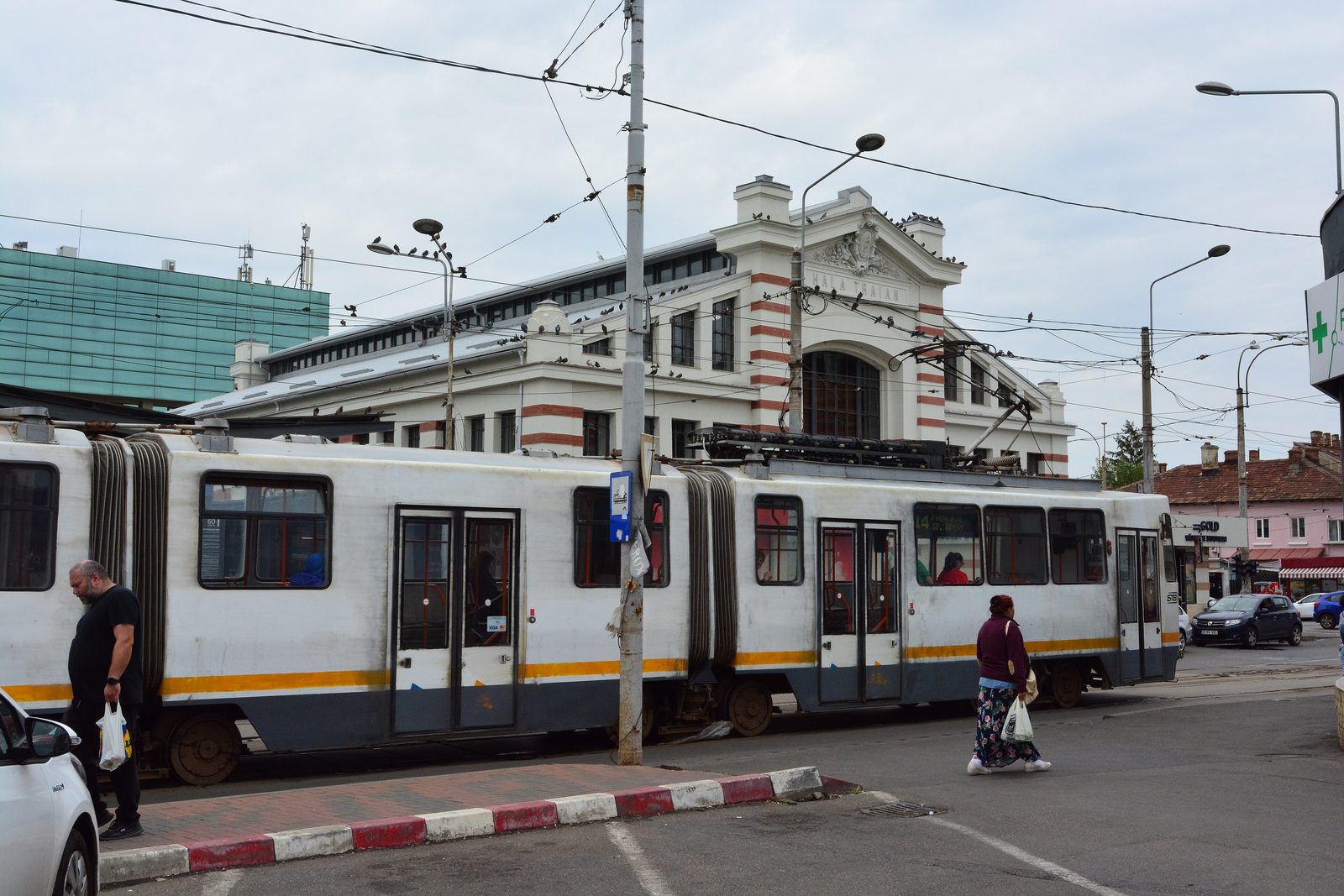 A tram passing in front of Hala Traian, the old market hall on Strada Traian in Bucharest, under overhead wires