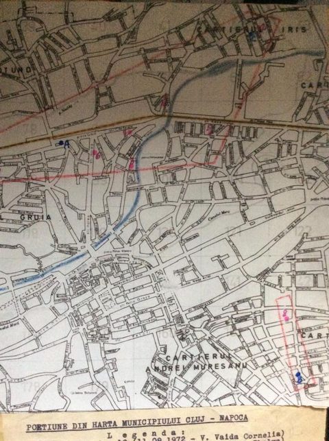 A printed street map of Cluj photographed from the case materials, the river drawn in blue and several streets ringed and marked in red and pink, with a typed caption below reading PORTIUNE DIN HARTA MUNICIPIULUI CLUJ NAPOCA and a legend that begins with the date 11.09.1972 and the name V. Vaida Cornelia