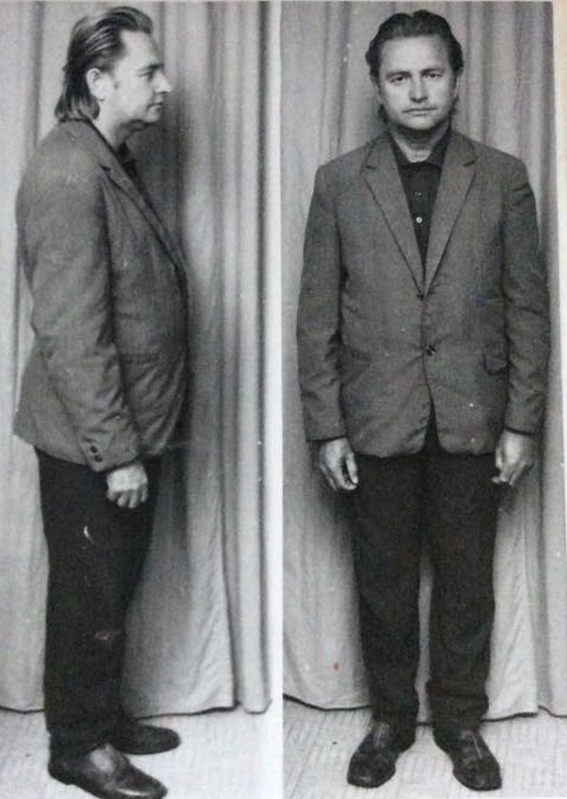 Two black and white full length militia identification photographs of the same man against a curtain, standing in profile on the left and facing the camera on the right, in a loose jacket and dark trousers