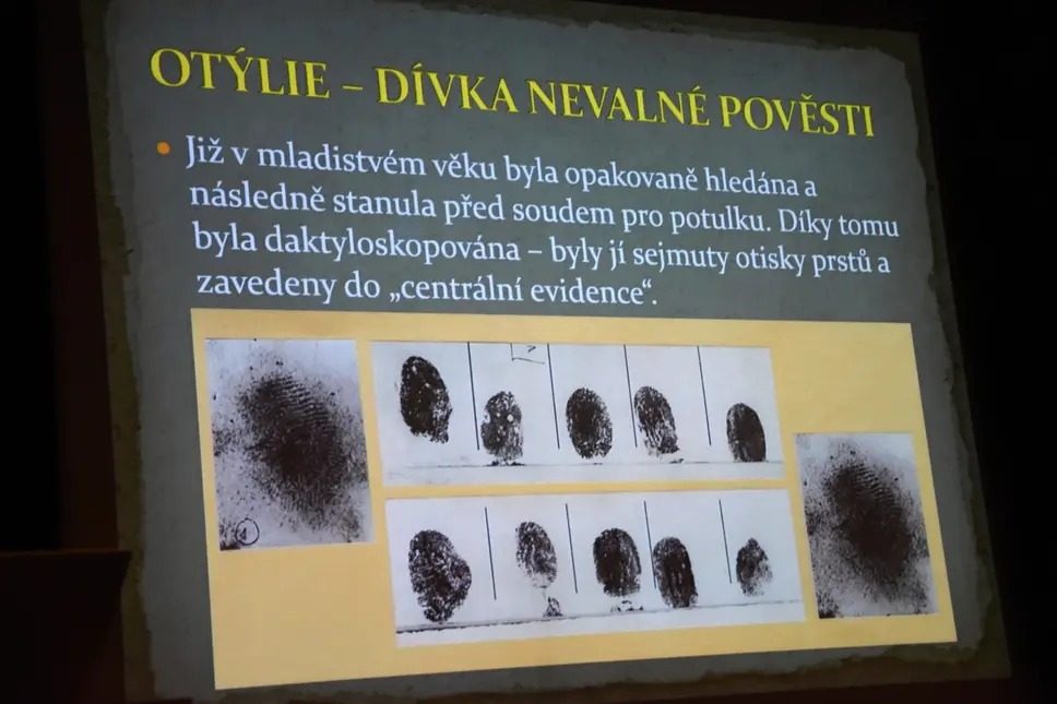 A projected lecture slide about Otýlie Vranská, with Czech text saying she was fingerprinted and the prints entered in the central register, and reproductions of the fingerprint cards below