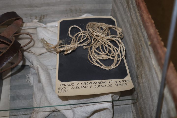 Coiled twine mounted on a dark card with a typed Czech caption, an exhibit at the Police Museum in Prague