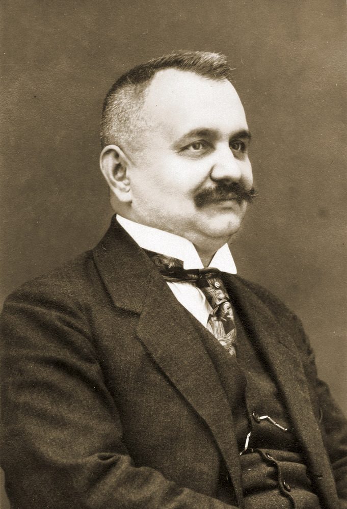 Josef Vaňásek in a studio portrait, in a dark suit and tie, with a moustache